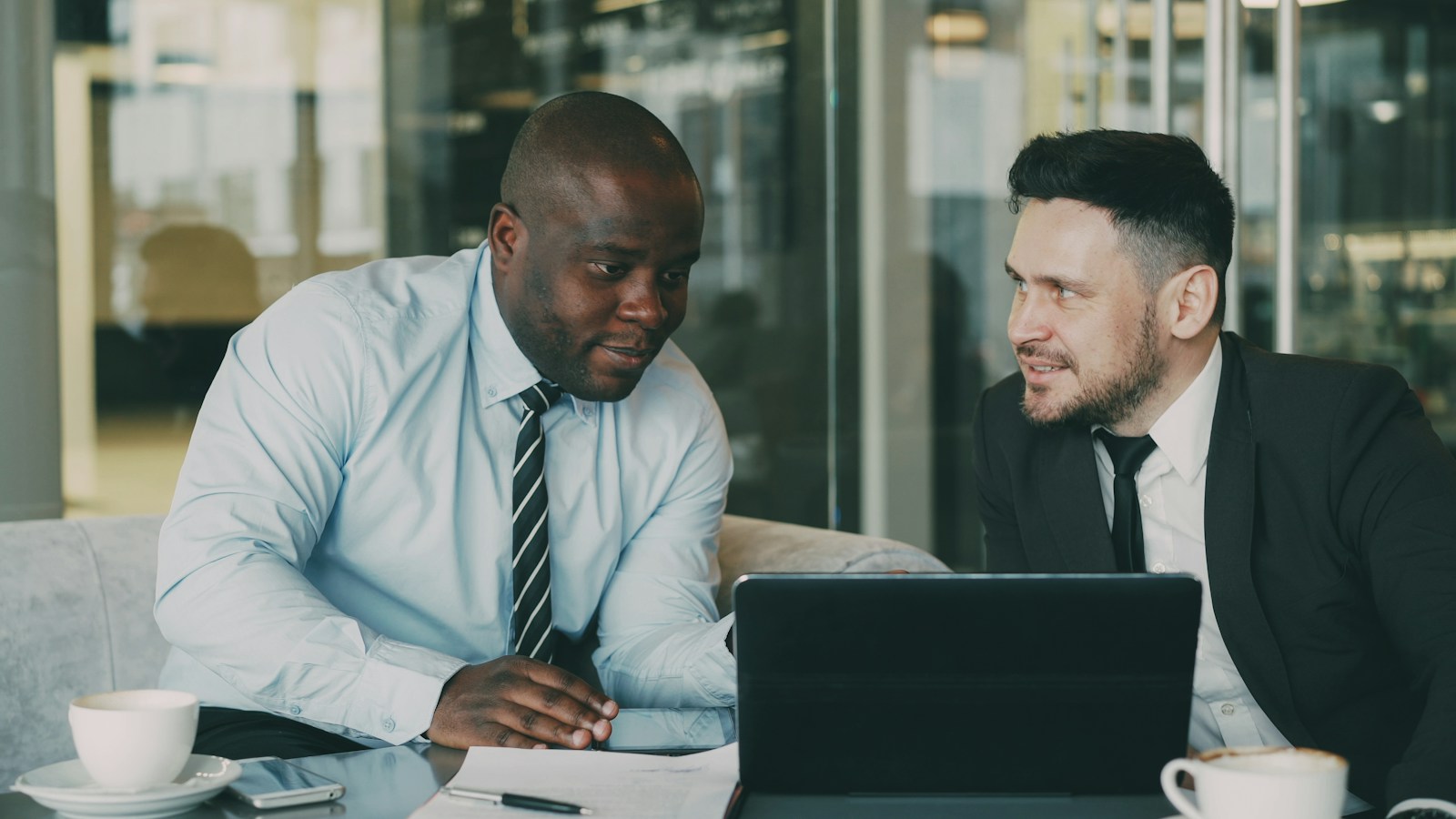 Two professionals from different firms reviewing documents together